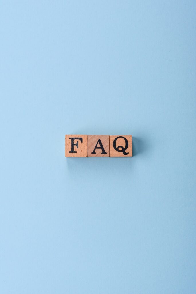 The inscription FAQ made up of wooden cubes on a plain background