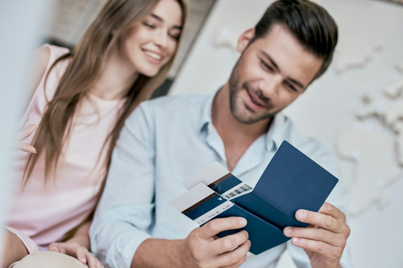 young-man-smiling-and-reviwing-tickets-passport-with-visa.jpg